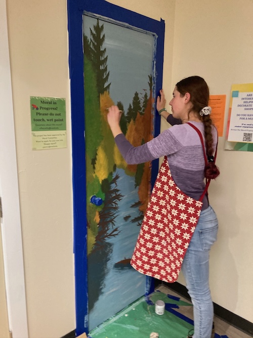 Me painting a door to have a lake and fall leaves on it